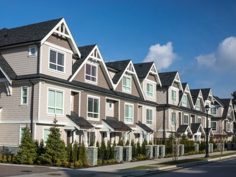 A row of houses on the side of a street.