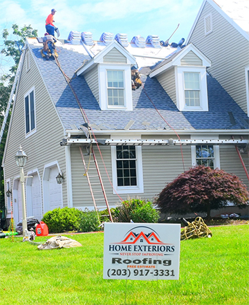 A home with a sign that says " home exteriors roofing ".