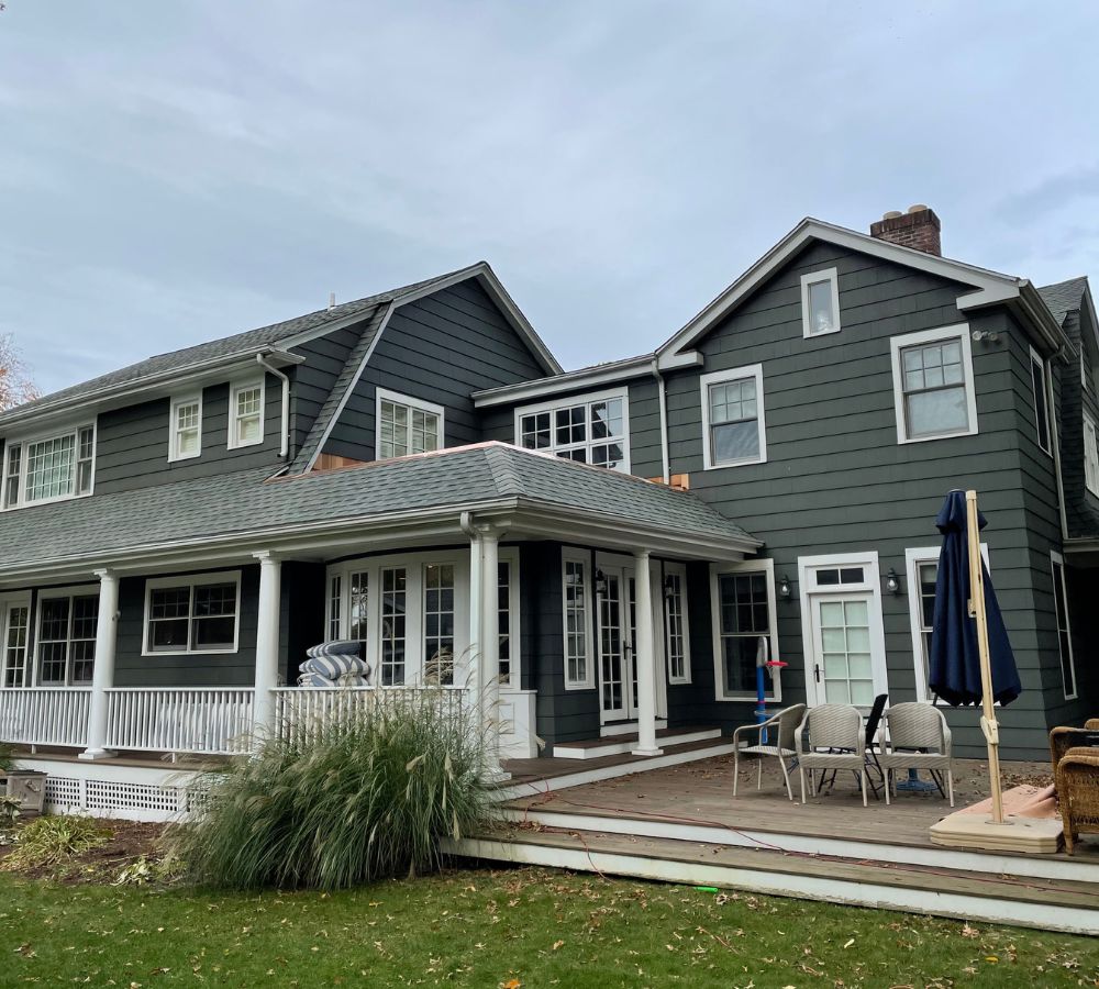A large house with a porch and lawn.